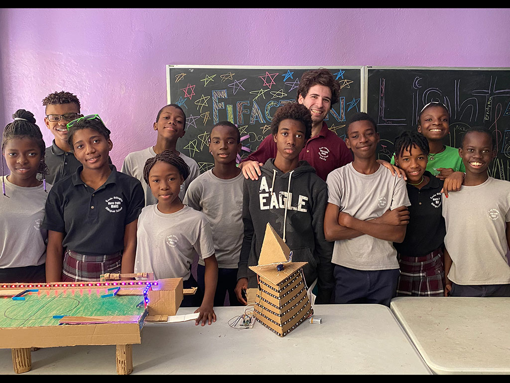 Caption:Mechanical engineering student, Eli Brooks, taught engineering toy design to children at the Have Faith Haiti Mission & Orphanage in Port-au-Prince, Haiti. Here, Brooks (back row, center) poses with his middle school class before they presented th