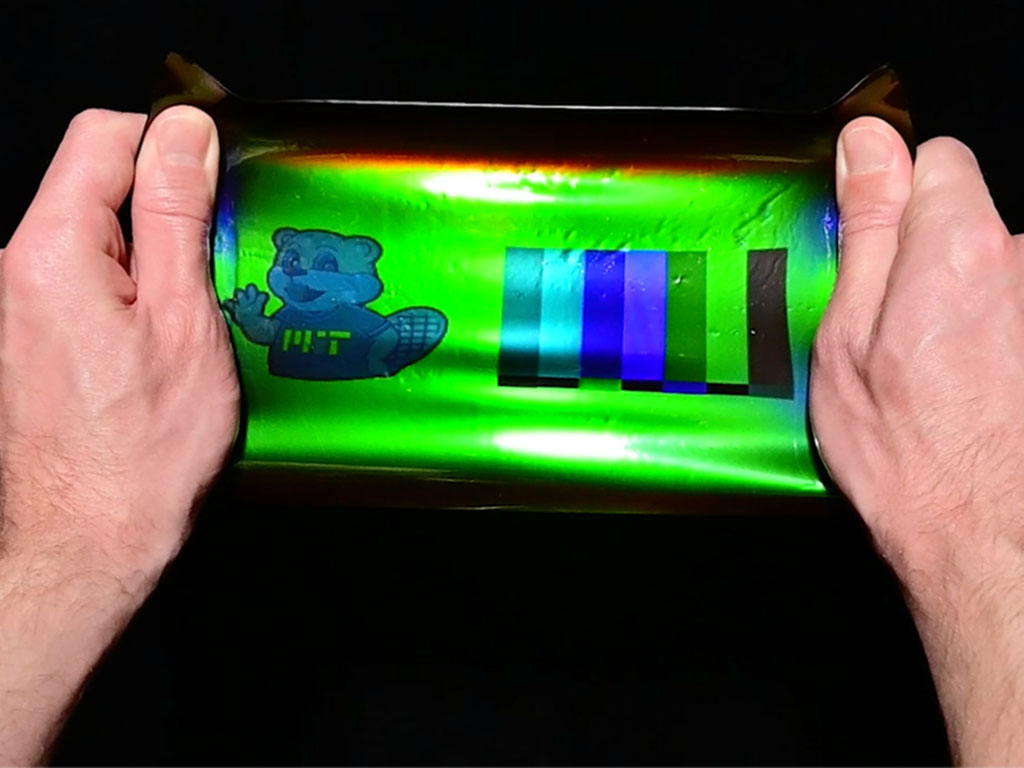 Caption:By applying a 19th-century color photography technique to modern holographic materials, an MIT team has printed large-scale images onto elastic materials that when stretched can transform their color, reflecting different wavelengths as the materi