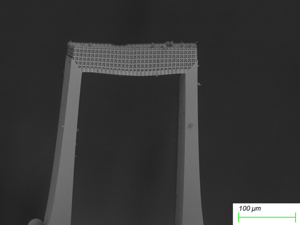 Closeup of the bridge-like metamaterial shows it is made of a honeycomb lattice. An inset shows the bridge is less 100 um thick.