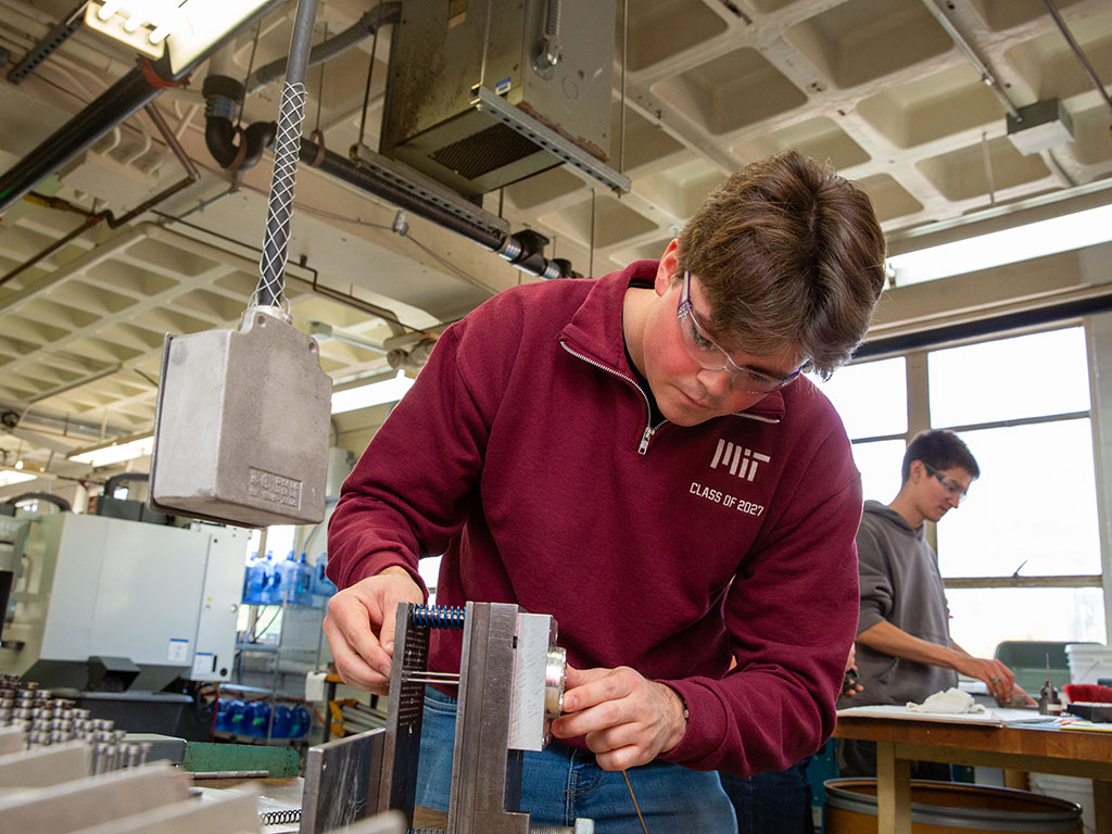 Adrian Yordanov '27 works attaches an Injection Molding Template to the guide rails for an Injection Molding Machine.
