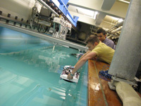 Students place model ships in a wave pool.