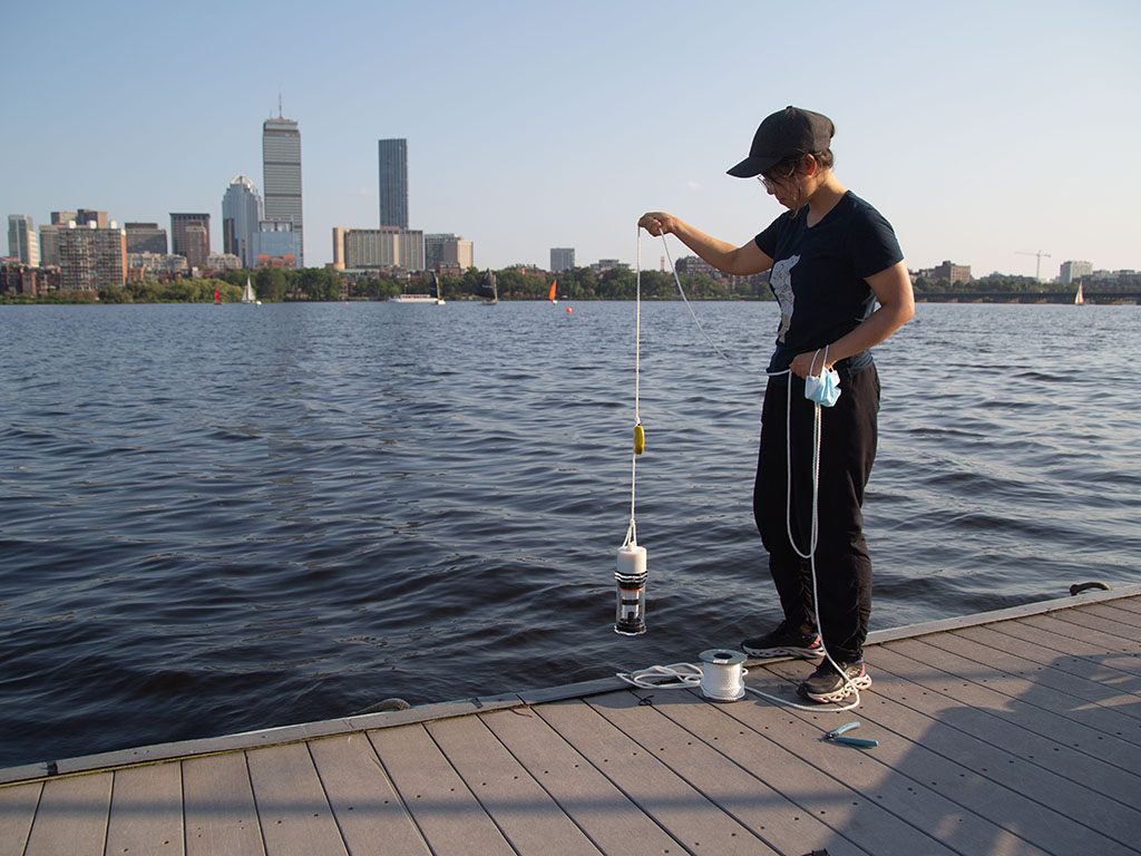 Charlene Xia, pictured at the MIT Sailing Pavilion, tests her microbiome monitoring system in the Charles River.