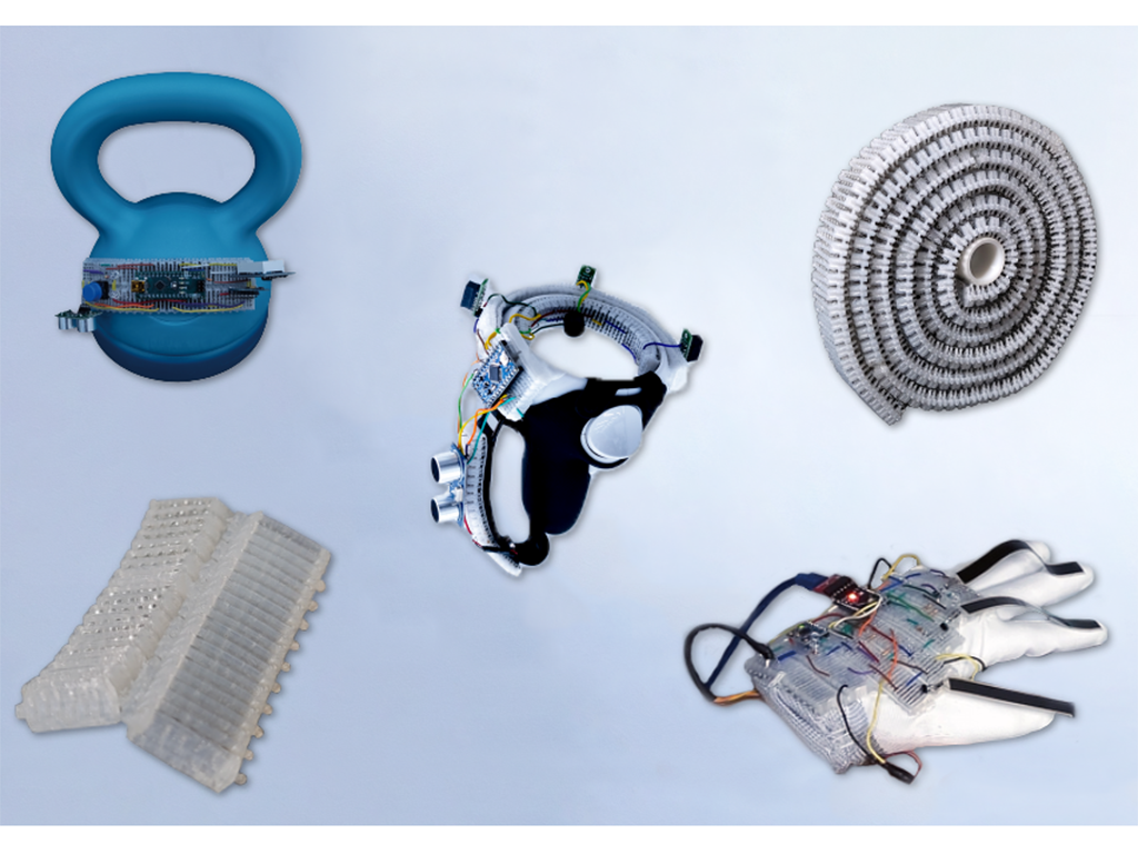 Five objects appear on a whitish background: A blue kettlebell with some microchip components, a silver ringlike object with wires, a roll of corrugated white plastic, a white glove with wires on it, and an off-white corrugated piece of plastic. 