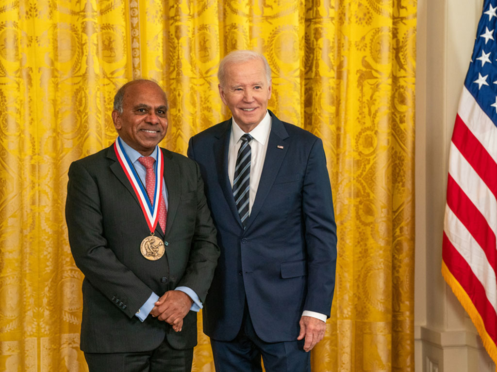 Subra Suresh, left, poses with President Joe Biden while wearing a gold medal