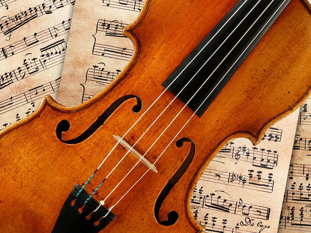 A violin with sheet music behind it