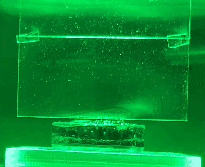 The puffs of white condensation on glass is water being evaporated from a hydrogel using green light, without heat